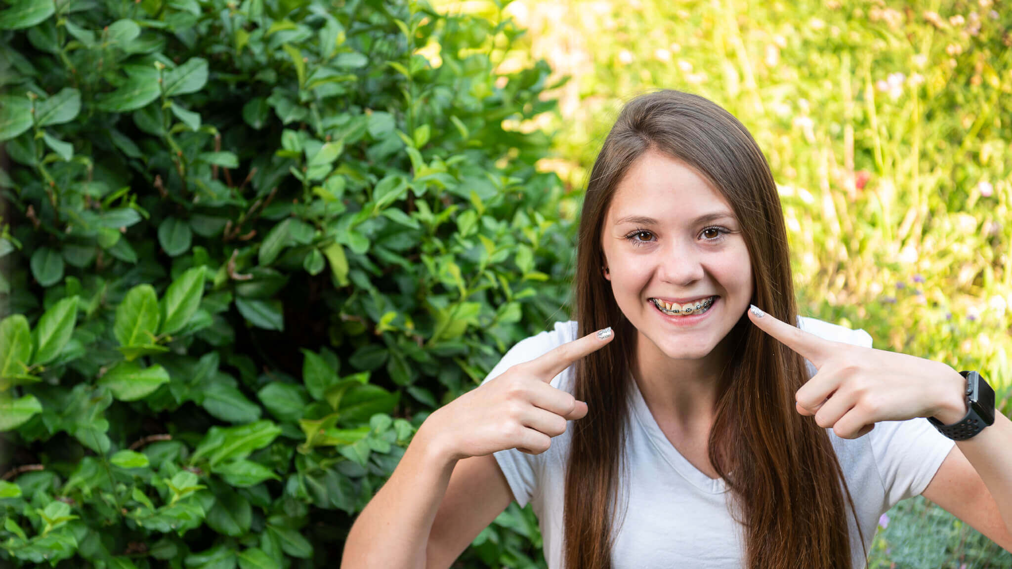 woman smiling behind forest background