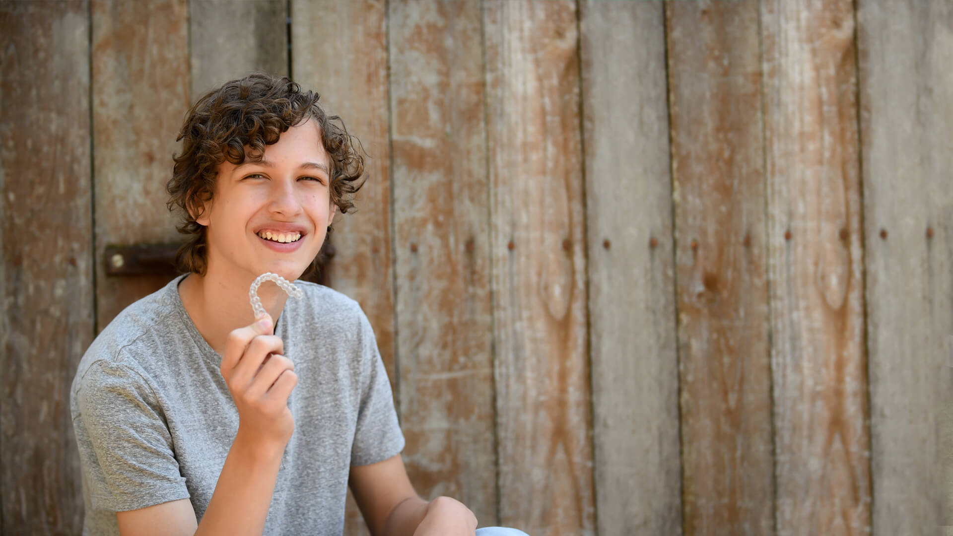 young man smiling with invisalign aligner